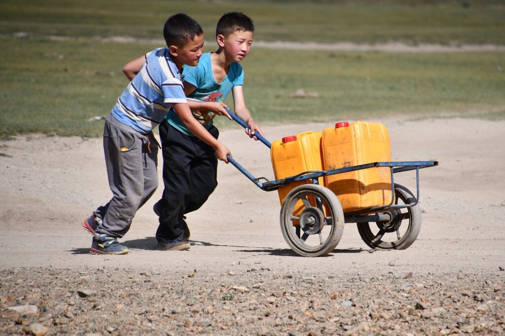 Dos niños de una comunidad pobre llevan dos tambos con agua ante la inaccesibilidad en este servicio.(Imagen de Ursula en Pixabay)