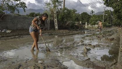 inundaciones causadas por el huracán Oscar en Guantánamo, mostrando calles anegadas y la labor de los servicios de emergencia asistiendo a los residentes.